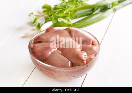 Raw chicken liver in glass bowl on wooden table Stock Photo