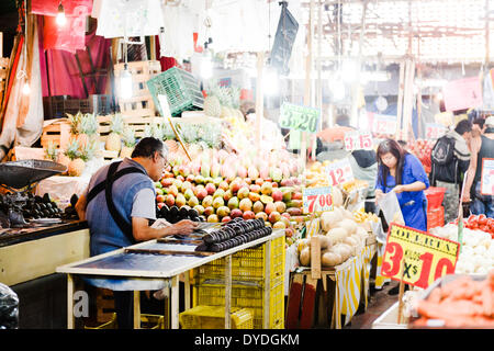A fruit vendor reading the paper at the Mercado de la Merced in Mexico City. Stock Photo