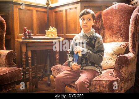 A young boy sitting with a book in Thornbury Castle. Stock Photo