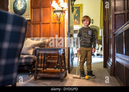 A boy plays croquet in the house at Thornbury Castle. Stock Photo