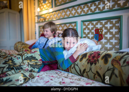 Two boys in onesies in the biggest hotel bed in Europe at Thornbury Castle. Stock Photo