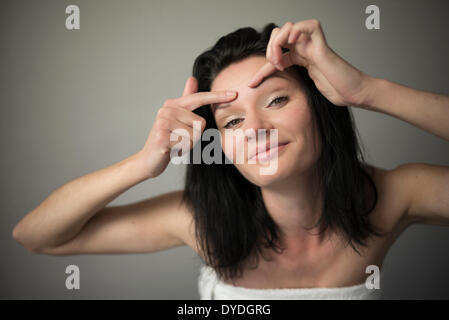 A beautiful cheeky girl squeezing her brow. Stock Photo