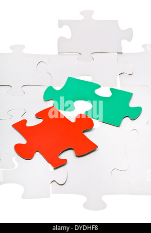 red and green pieces on layer of connected white puzzles Stock Photo