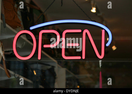 A red and blue open sign in the window of a store Stock Photo