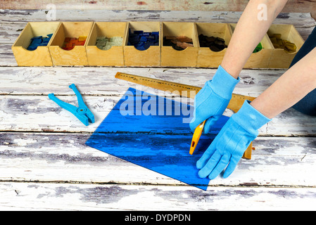 Artist cutting sheets of stained glass into small mosaic squares Stock Photo