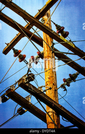 Power cables attached to telephone pole with High Voltage warning sign Stock Photo