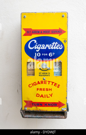 An antique cigarette vending machine on a wall in the UK Stock Photo