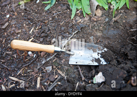 a shovel left by a gardener in a garden in spring Stock Photo