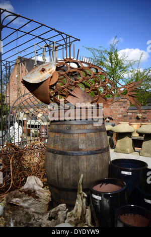 A fish sculpture using reclaimed items such as horseshoes, spanners, and garden fork tines. Photographed at a garden store. Stock Photo
