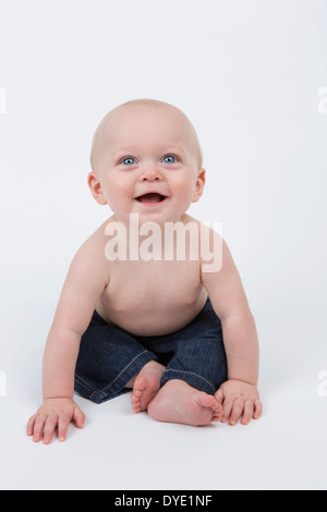 Happy Smiling 6 month old Baby Boy Wearing Blue Jeans Stock Photo