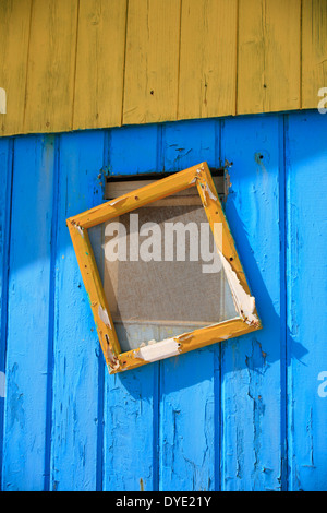 old window frames with cracked and peeling paint near the wall of ...