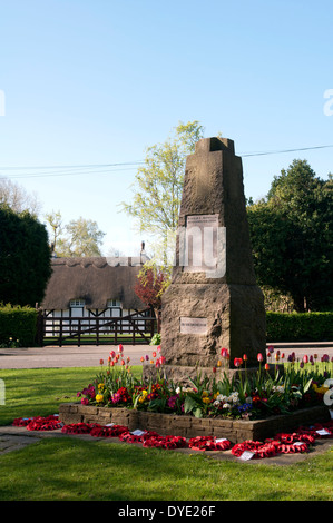 War memorial and thatched cottage, Old Bletchley, Buckinghamshire, England, UK Stock Photo
