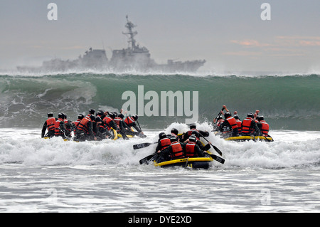 US Navy SEAL team candidates paddle into the high waves during Surf Passage tests at Naval Amphibious Base Coronado during the first phase of SEAL training January 21, 2014 in San Diego, California. Stock Photo