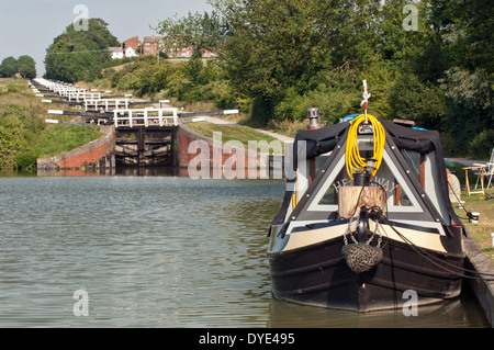 A narrowboat moored at the bottom of the flight of locks on the Kennet & Avon canal at Caen Hill near Devizes, Wiltshire, UK Stock Photo