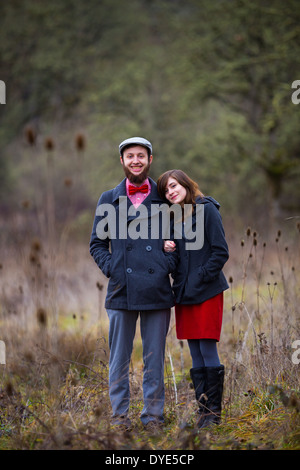 Portrait of a happy couple engaged to be married in the winter outdoors. This couple is modern, trendy, hipster, and fashion fir