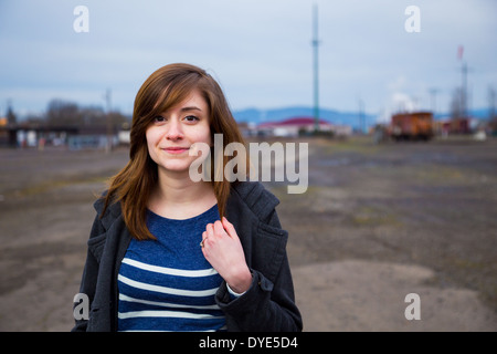 Modern, trendy, hipster girl in an abandoned train yard at dusk in this fashion style portrait. Stock Photo
