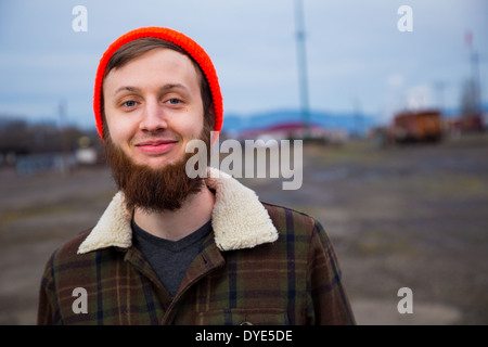 Modern, trendy, hipster guy in an abandoned train yard at dusk in this fashion style portrait. Stock Photo