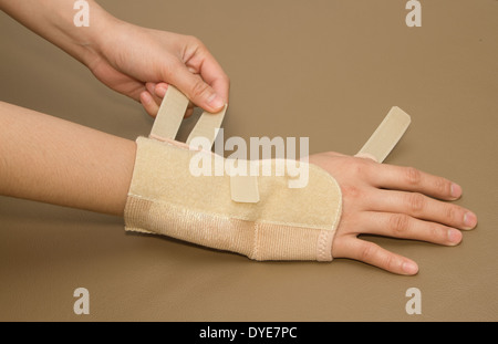 woman's hand with carpal tunnel syndrome remove the wrist brace Stock Photo