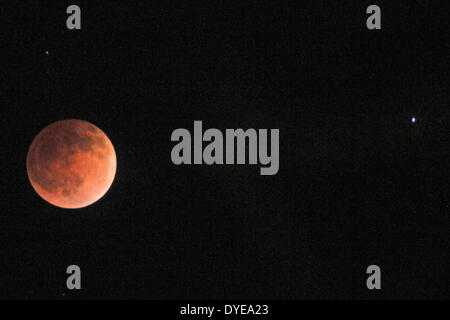 Anchorage, Alaska, USA. 14th Apr, 2014. The Earth's shadow cast a blood-red hue on the face of the moon, called the Blood Moon. The total lunar eclipse, which was visible from most of North and South America, Hawaii and Alaska. lasted about 3.5 hours between late Monday night and early Tuesday. The April 14th eclipse is the first of four consecutive total lunar eclipses that will occur between April 2014 and September 2015. The planet Mars also made its closest approach to Earth since 2008, during the same time as this lunar eclipse, making this a once in a lifetime event. (Credit Image: © Stock Photo