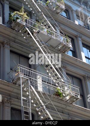 New York City tenement buildings in midtown New York. A mixture of housing and offices, this typical architecture dominated the city to the beginning of the 20th century, when elevators became widespread, enabling skyscapers. Stock Photo