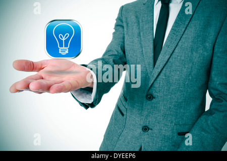 man wearing a suit with an icon with a light bulb in his hand Stock Photo