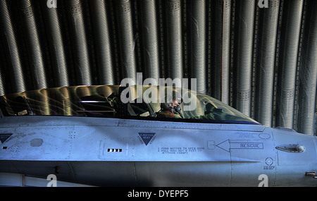 Polish air force pilot Maj. Przemyslaw Struj taxis out of a protective aircraft shelter in a F-16C fighter jet before a training mission with US Air Force at Lask Air Base April 2, 2014 Lodz, Poland. Stock Photo