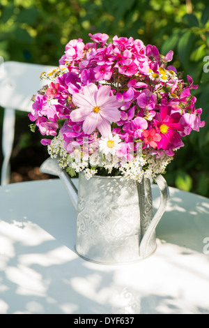 Summer flowers in a watering can Stock Photo