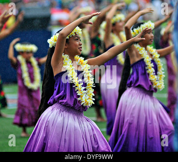 Traditional Hawaiian dancers perform Hula as a light rain falls January 17, 2013 in Honolulu, Hawaii. Stock Photo