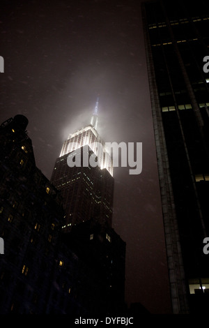 The art-deco architecture of New York's Empire State Building at night in a snowstorm Stock Photo