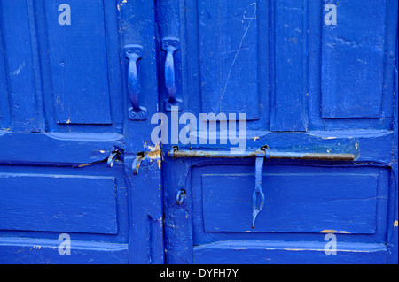 Open sliding bolt lock on closed blue wooden door Stock Photo