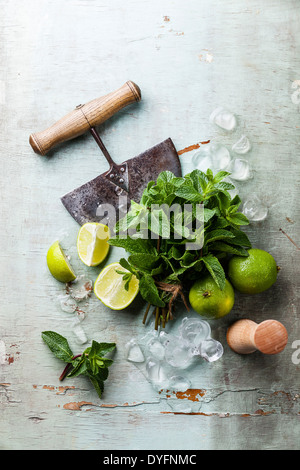Ingredients for making mojitos Ice cubes, mint leaves and lime on blue background Stock Photo