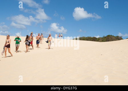 Young travelers walking across the Fraser Island Lake Wabby sand blow towards the lake in March 2014. Stock Photo