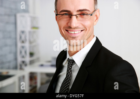 Happy businessman in glasses standing at office Stock Photo