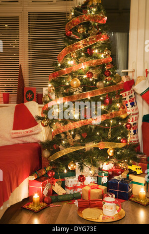 Presents under an illuminated christmas tree Stock Photo