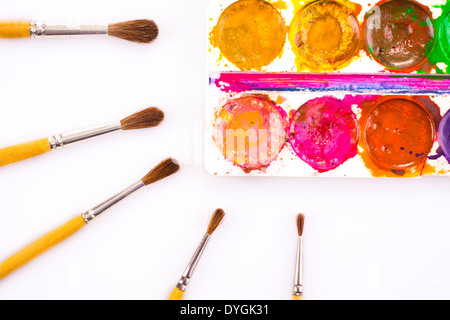 Set of used watercolor paints and paintbrushes on white Stock Photo