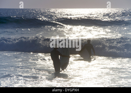 Two surfers heading out into the waves. Stock Photo