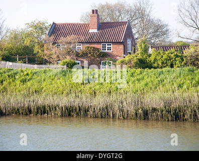 Riverside cottage on the banks of the River Alde at Snape, Suffolk, England Stock Photo