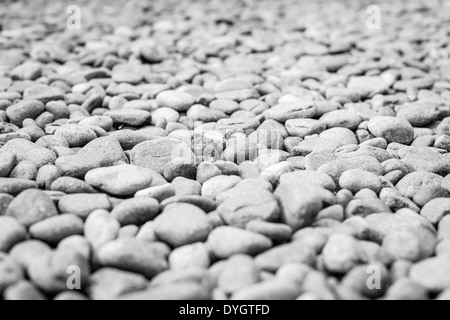 Pebble heap as abstract natural background. Plenty of grey and brown gravel stones in close-up view. Stock Photo