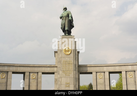 White clouds view soldier statue looking down from gilded Cyrillic words stoa, Soviet War Memorial, Strasse des 17 Juni, Berlin