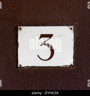 house number three. Brown lettering on a white plastic plate Stock Photo