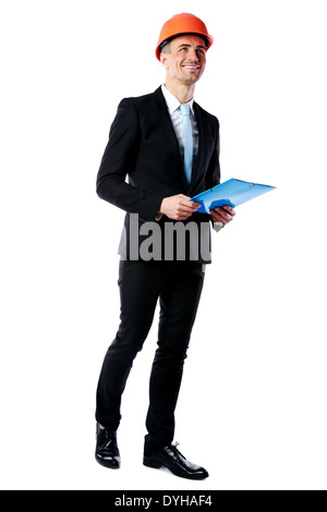 Full length portrait of a happy businessman in helmet holding blue folder over white background Stock Photo