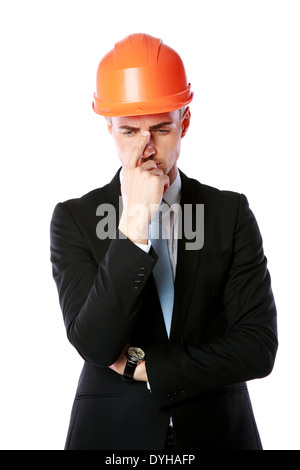 Portrait of a pensive businessman in orange helmet isolated on a white background Stock Photo