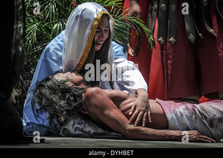 San Fernando, Philippines. 18th Apr, 2014. Penitents take part in a reenactment of Jesus Christ's crucifixion during Good Friday in San Fernando town, Pampanga province, Philippines, April 18, 2014. Crucifixions remain a common practice during Holy Week throughout the country despite being strongly condemned by the Roman Catholic church. Penitents who take part believe the act will atone them for their sins and give them blessings.Photo: Ezra Acayan/NurPhoto Credit:  Ezra Acayan/NurPhoto/ZUMAPRESS.com/Alamy Live News Stock Photo