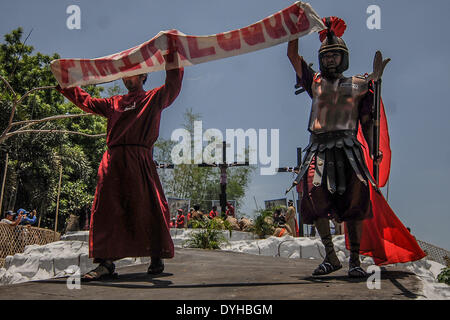 San Fernando, Philippines. 18th Apr, 2014. Penitents take part in a reenactment of Jesus Christ's crucifixion during Good Friday in San Fernando town, Pampanga province, Philippines, April 18, 2014. Crucifixions remain a common practice during Holy Week throughout the country despite being strongly condemned by the Roman Catholic church. Penitents who take part believe the act will atone them for their sins and give them blessings.Photo: Ezra Acayan/NurPhoto Credit:  Ezra Acayan/NurPhoto/ZUMAPRESS.com/Alamy Live News Stock Photo