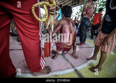 San Fernando, Philippines. 18th Apr, 2014. The bloodied back of a flagellant is seen during Good Friday in San Fernando town, Pampanga province, Philippines, April 18, 2014. Crucifixions remain a common practice during Holy Week throughout the country despite being strongly condemned by the Roman Catholic church. Penitents who take part believe the act will atone them for their sins and give them blessings.Photo: Ezra Acayan/NurPhoto Credit:  Ezra Acayan/NurPhoto/ZUMAPRESS.com/Alamy Live News Stock Photo