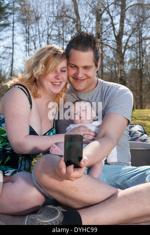 Young family is taking a selfie picture with their smartphone Stock Photo