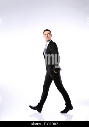 Full length portrait of a businessman walking on gray background Stock Photo