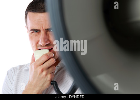 Closeup portrait of a man roaring loudly into megaphone Stock Photo