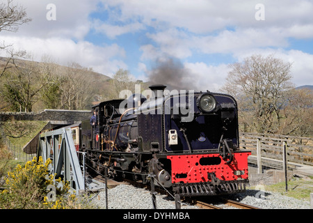 Welsh Highland Railway steam train crossing Afon Glaslyn River bridge in Aberglaslyn Pass Beddgelert Gwynedd North Wales UK Stock Photo