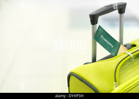Bright suitcase with handle and label economy. Luggage at airport. Modern and elegant bag for travel. Object on white background Stock Photo
